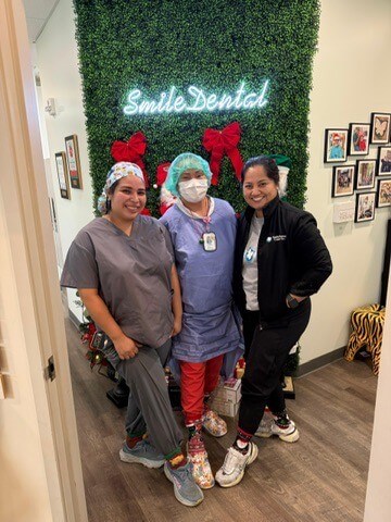 The Smile Dental Center team at the holiday-decorated wall