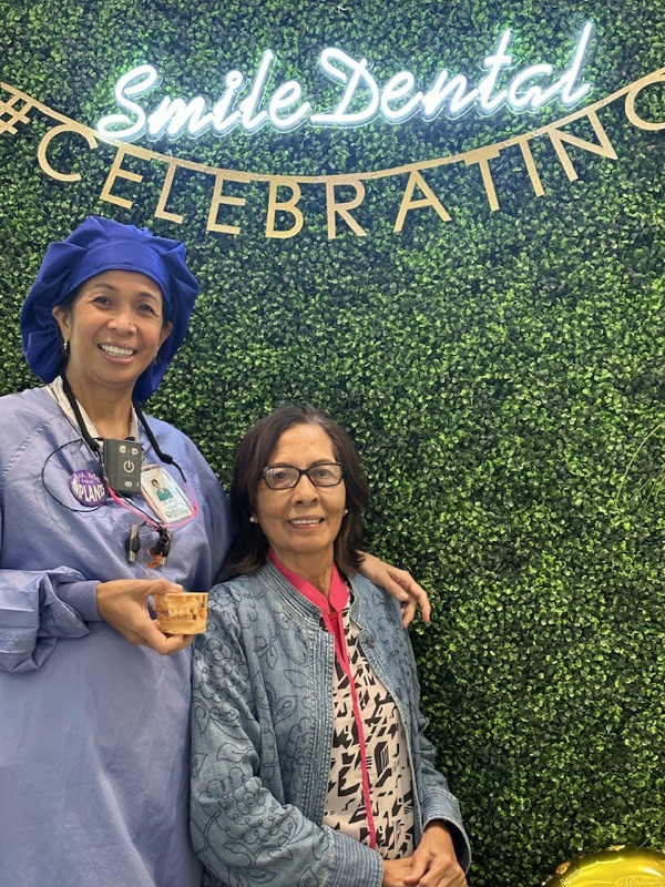 A team member and a patient smiling together at our office