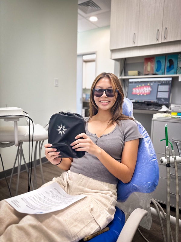 A happy Invisalign patient relaxing in the treatment chair