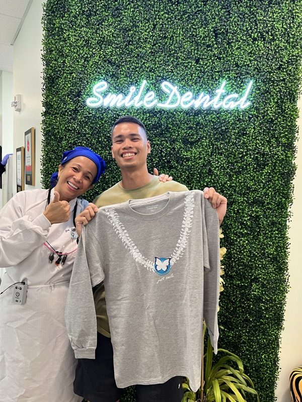 A team member showing off a Smile Dental shirt