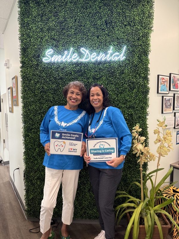 Team members at the Smile Dental wall