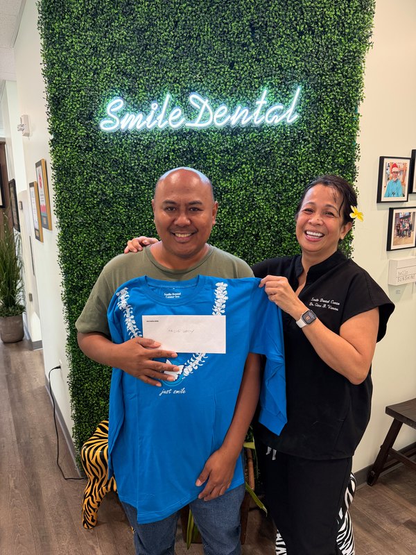 A smiling patient holding a gift at our office